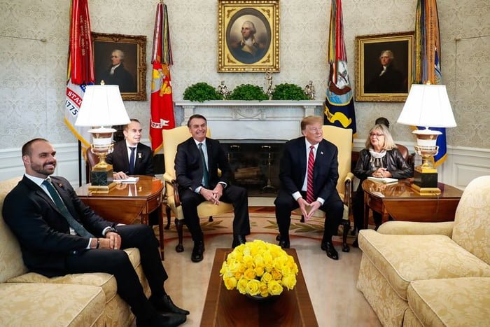 Eduardo Bolsonaro e Jair Bolsonaro no Salão Oval da Casa Branca (EUA), juntamente com Donald Trump