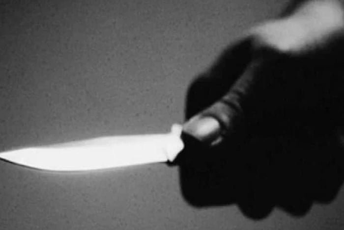 Imagem em preto e branco mostra pessoa segurando faca