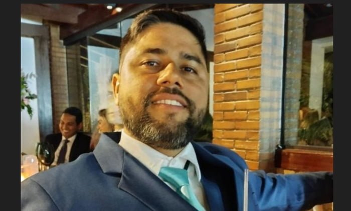 Flamenguista Jonathan Messias Santos da Silva de terno e com um copo na mão; ele é acusado de arremessar garrafa que matou torcedora palmeirense em SP