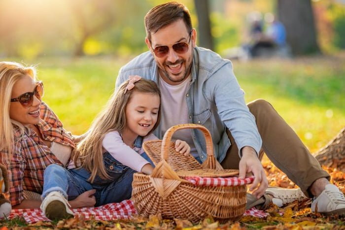 Dia dos pais comemorado com piquenique em um parque com cesta de comidinhas, mãe, filha e pai - Metrópoles