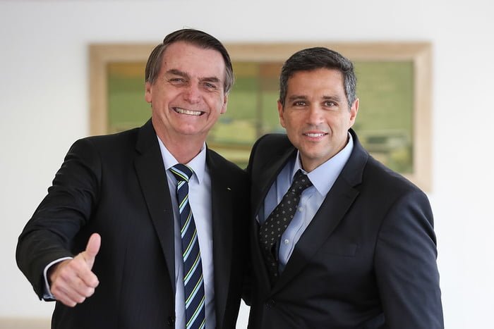 Jair Bolsonaro, então presidente da República, faz sinal de positivo ao posar para foto com o presidente do Banco Central, Roberto Campos Net, em fevereiro de 2019