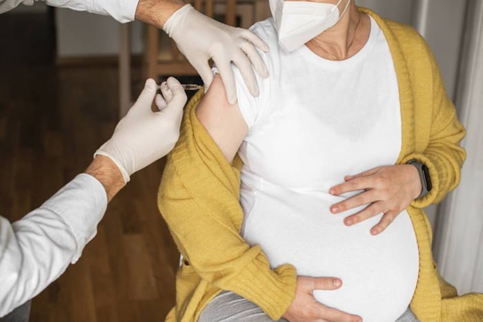 Imagem colorida de mulher tomando vacina durante gestação