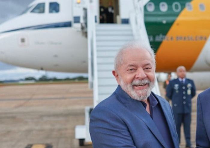 Em foto colorida, Lula aparece diante do avião presidencial