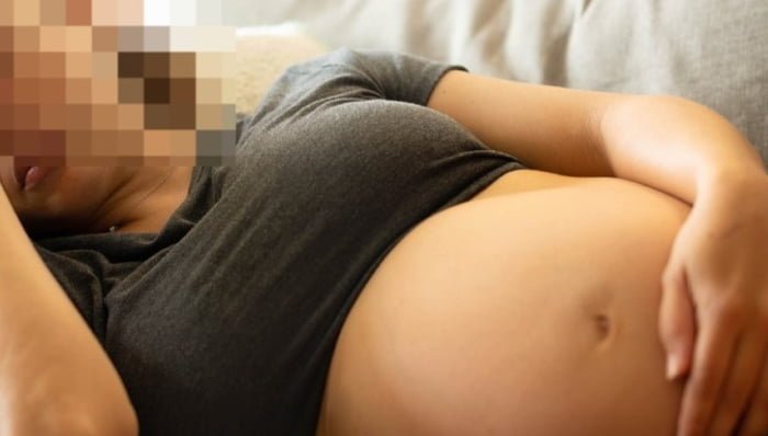 Imagem colorida de grávida com a mão na barriga - Metrópoles