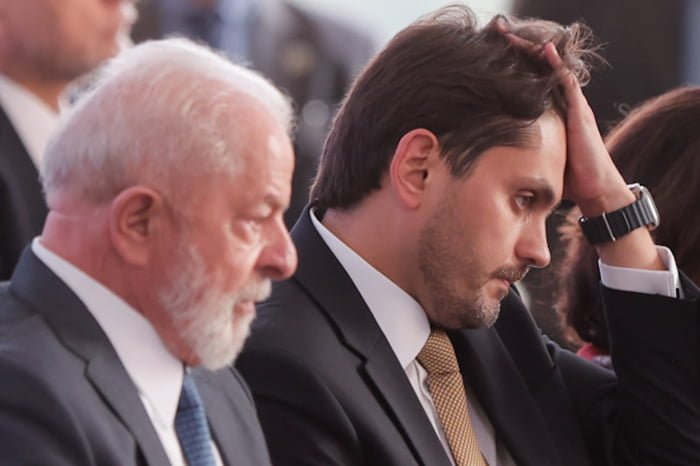 Ministro Juscelino Filho passa a mão no cabelo ao lado do presidente Lula - metrópoles