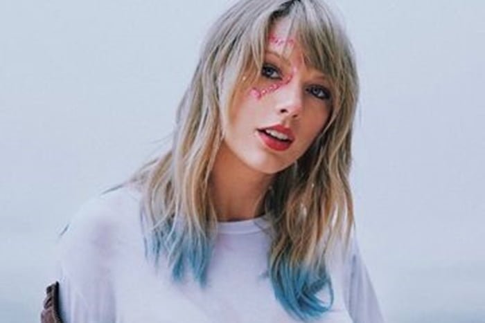 Taylor Swift posa fazendo carão com uma blusa branca e o rosto pintado- Metrópoles