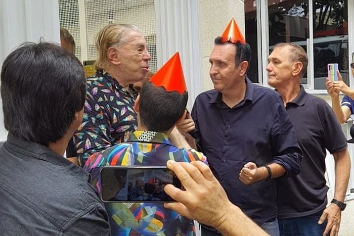 Foto colorida de Silvio Santos com fãs na porta de sua casa - Metrópoles