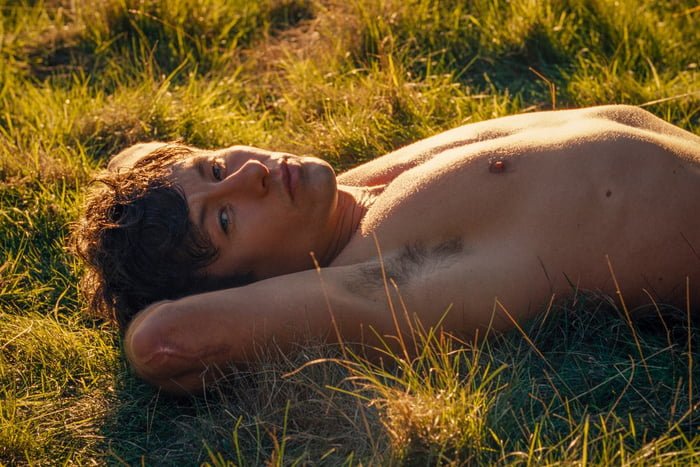 Homem sem camisa deitado sobre a grama - Metrópoles