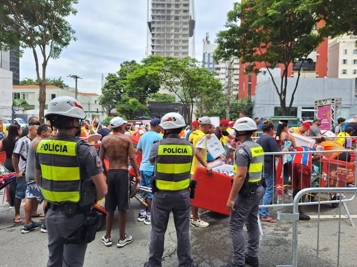 Imagem colorida mostra PMs no local de acesso aos desfiles de Carnaval - Metrópoles