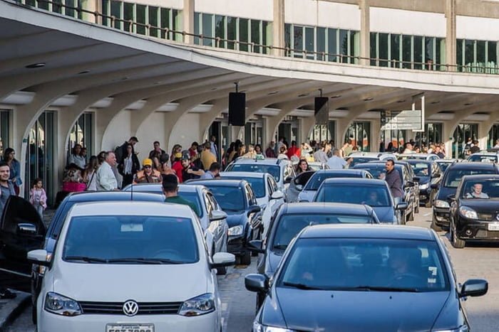 Imagem de via de acesso do aeroporto de Congonhas lotada de carros, taxistas e passageiros - Metrópoles