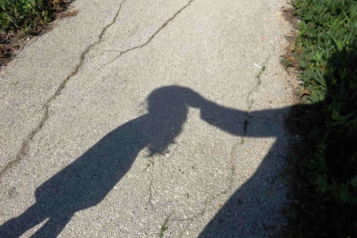Imagem colorida mostra sombra de homem adulto com a mão na cabeça de uma criança menina, ilustrando um ato de pedofilia ou estupro de vulnerável pena de morte - Metrópoles