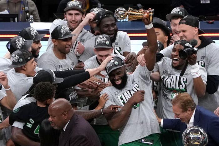 Jaylen Brown #7 do Boston Celtics levanta troféu de MVP "Larry Bird" cercado por outros jogadores