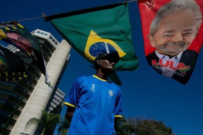 Homem negro próximo à bandeira do Brasil pendurada