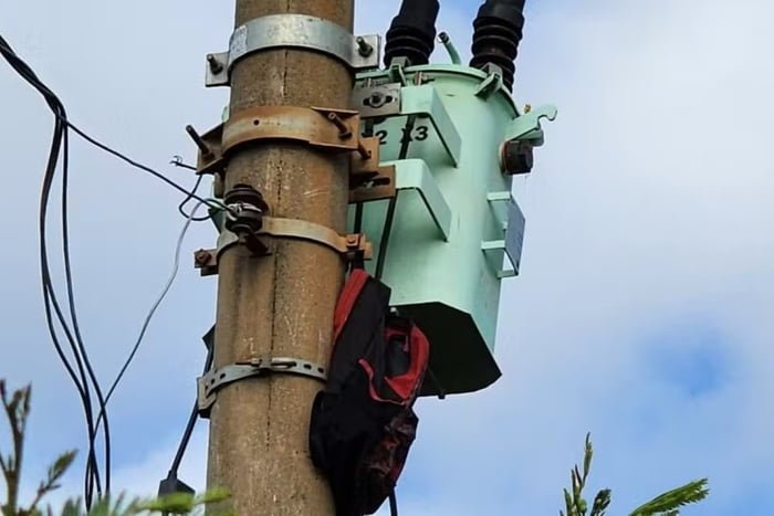 Imagem colorida de poste com mochila pendurada. Homem que tentava furtar cabos foi encontrado morto perto do poste - Metrópoles