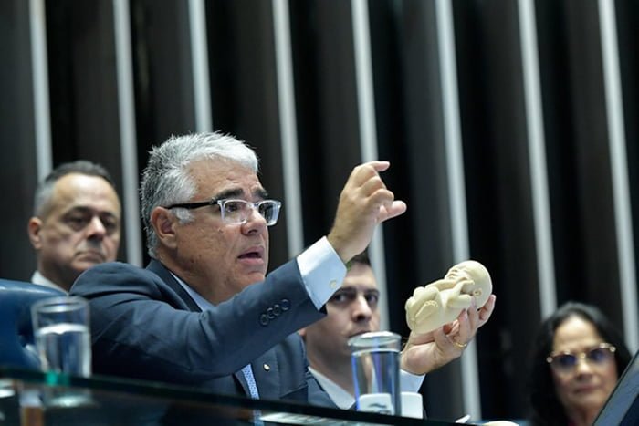 Foto colorida do senador Eduardo Girão (Novo-CE) ao exibir réplica de feto - Metrópoles
