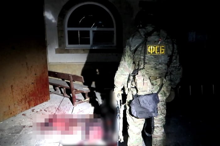 Policial observa manchas de sangue após confronto com terroristas na Rússia