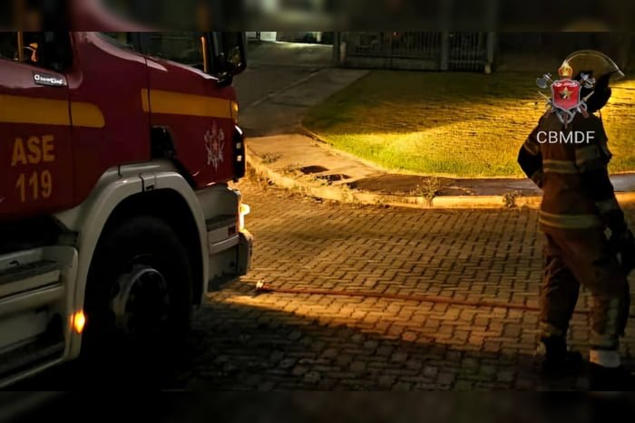 Imagem colorida de uma viatura do CBMDF e um bombeiro militar à direita